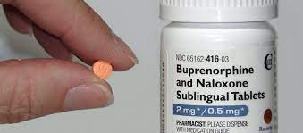 Person holding a buprenorphine/naloxone tablet